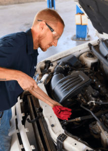 Student servicing automobile