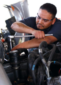 Young man working on diesel truck engine