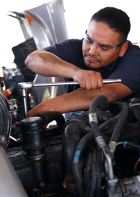 Male Automotive Student Working on Diesel Truck Engine