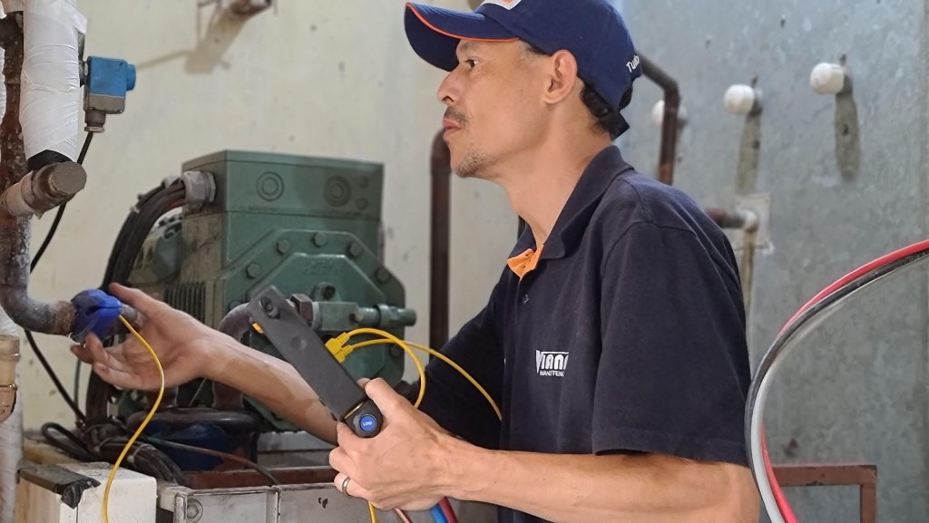An hvac technician working on a refrigeration unit